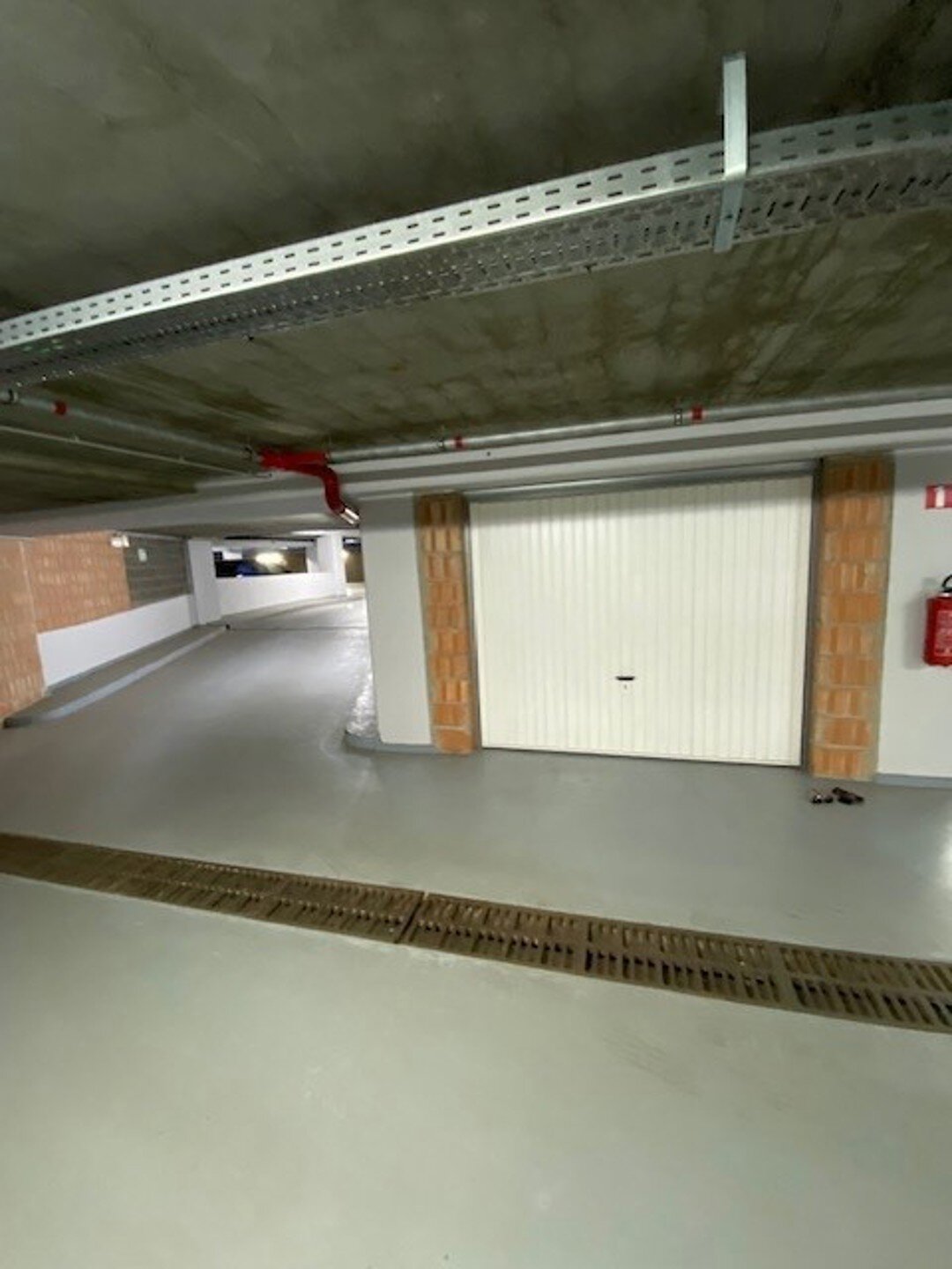 Deze garagebox bevindt zich ondergronds op -1; heeft een hoogte van 1,90 m - breedte aan de kant van de poort 3 m; diepte 5 m en breedte achteraan 5,15 m.
Aangezien de garagebox afzonderlijk wordt verhuurd, is een BTW van 21% verschuldigd bovenop de huurp