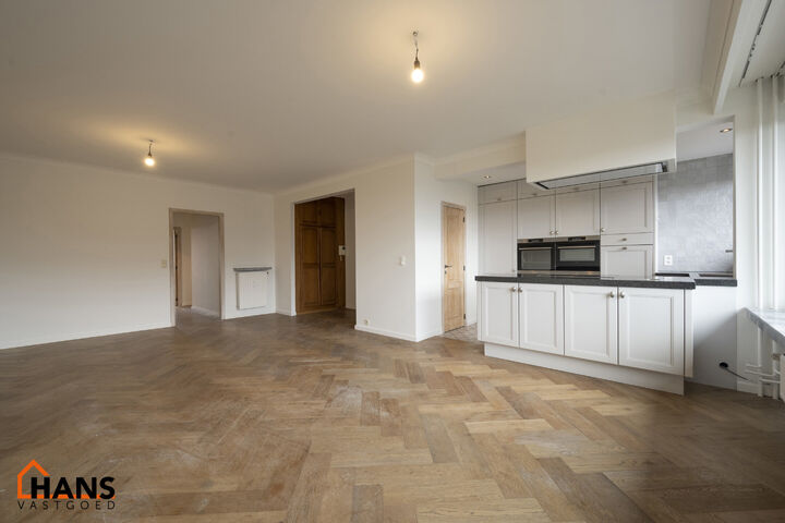 Instapklaar appartement op de zesde verdieping met garagebox omvat inkom met vestiairekast; woonkamer; open en ge&iuml;nstalleerde keuken met toestellen: koelkast, vriezer, kookplaat op inductie, vaatwasser, dampkap combioven, oven, kasten, spoelbak en een ex