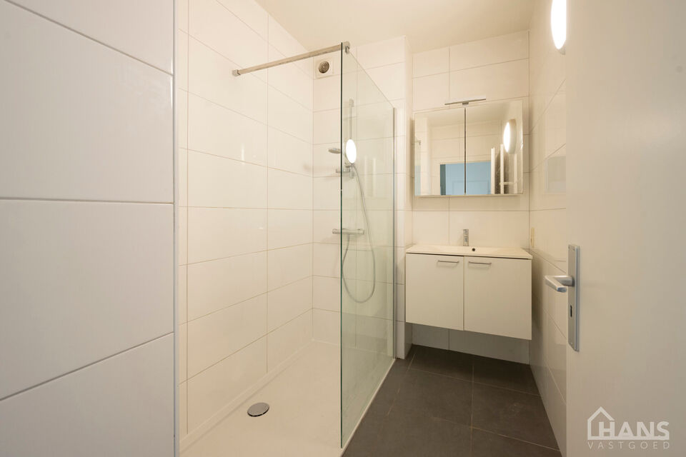Inkomhal; apart toilet; leefruimte; keuken met kasten, kookplaat, dampkap en oven; badkamer met inloopdouche, spiegelkast en wastafel in meubel; 2 slaapkamers waarvan de kleinste toegang verleent naar het achterliggend terras.  Bijkomend is er een garageb