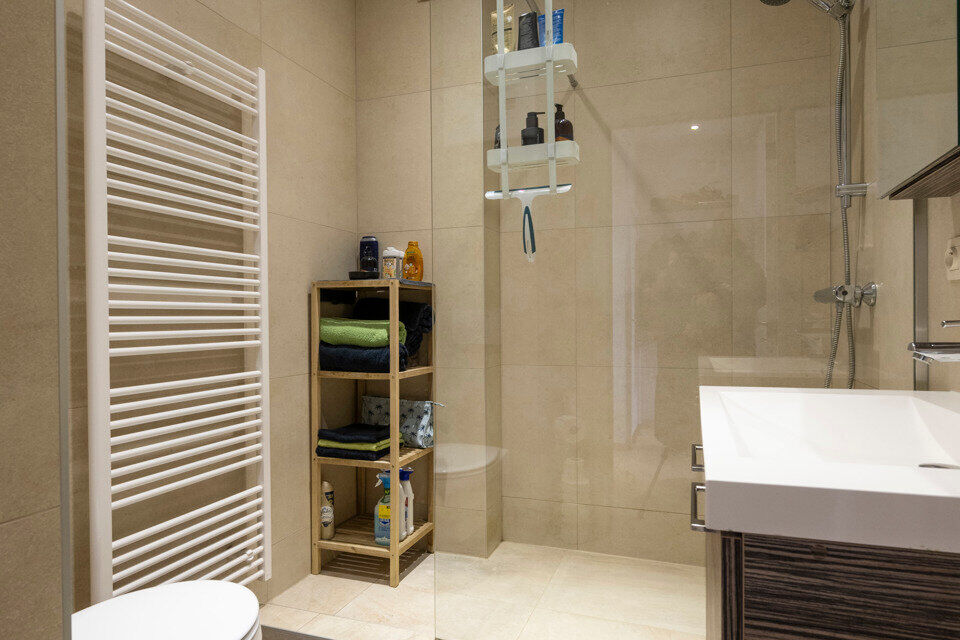 Inkomhal; leefruimte; keuken met vele kasten, lades, gasvuur, dampkap; spoelbak, oven, microgolf, vaatwasser en koelkast, toegang tot achterliggend terras; berging met aansluiting voor wasmachine en droogkast; badkamer met ruime douche, wastafel in meubel