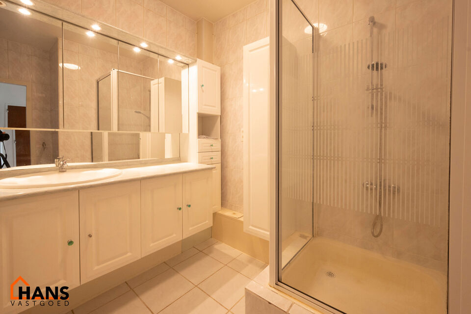 Inkomhal met vestiairekast; leefruimte met halfopen vernieuwde keuken met kookplaat, spoelbak en koelkast; apart toilet; badkamer met douche, badkamermeubel met kasten, spiegels en spoelbak; 2 slaapkamers waarvan de hoofdslaapkamer toegang geeft tot een r