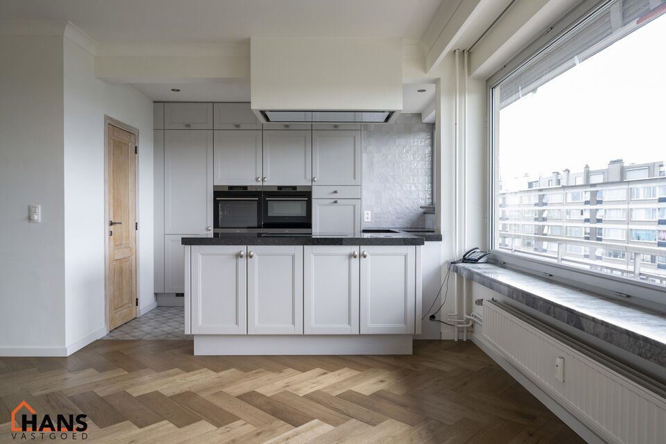 Instapklaar appartement op de zesde verdieping met garagebox omvat inkom met vestiairekast; woonkamer; open en ge&iuml;nstalleerde keuken met toestellen: koelkast, vriezer, kookplaat op inductie, vaatwasser, dampkap combioven, oven, kasten, spoelbak en een ex