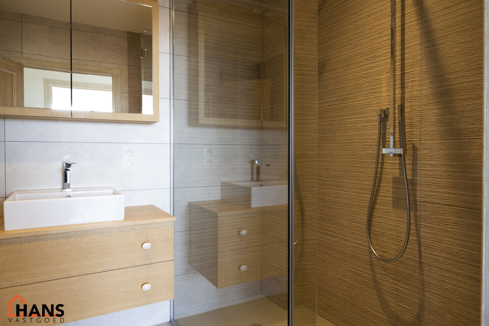 Instapklaar appartement op de zesde verdieping met garagebox omvat inkom met vestiairekast; woonkamer; open en ge&iuml;nstalleerde keuken met toestellen: koelkast, vriezer, kookplaat op inductie, vaatwasser, dampkap combioven, oven, kasten, spoelbak en een ex