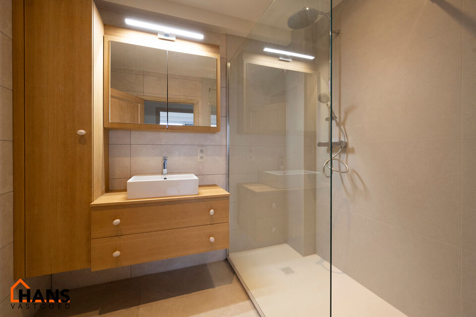 Instapklaar appartement op de zesde verdieping met garagebox omvat inkom met vestiairekast; woonkamer; open en ge&iuml;nstalleerde keuken met toestellen: koelkast, vriezer, kookplaat op inductie, vaatwasser, dampkap combioven, oven, kasten, spoelbak en een ex