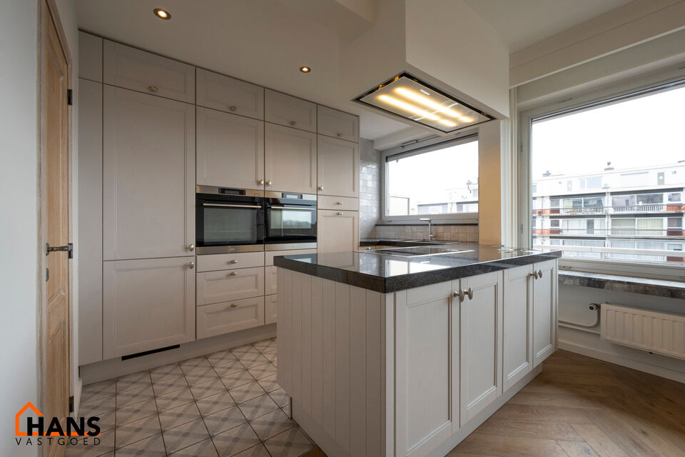 Instapklaar appartement op de zesde verdieping met garagebox omvat inkom met vestiairekast; woonkamer; open en ge&iuml;nstalleerde keuken met toestellen: koelkast, vriezer, kookplaat op inductie, vaatwasser, dampkap combioven, oven, kasten, spoelbak en een ex