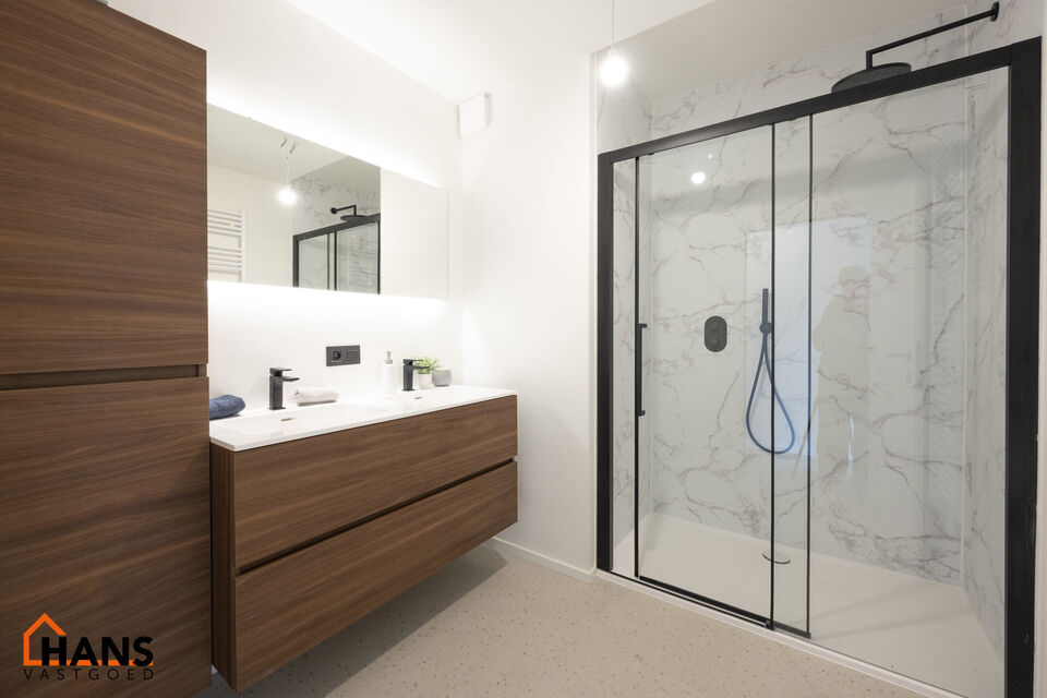 IN OPTIE!! Op de tweede verdieping van een kleinschalig gebouw (zonder lift) bevindt zich dit stijlvol gerenoveerde appartement. Bij binnenkomst treft u een inkomhal met ruimte voor een vestiairekast en een gastentoilet met wastafelmeubel.
De ruime en li