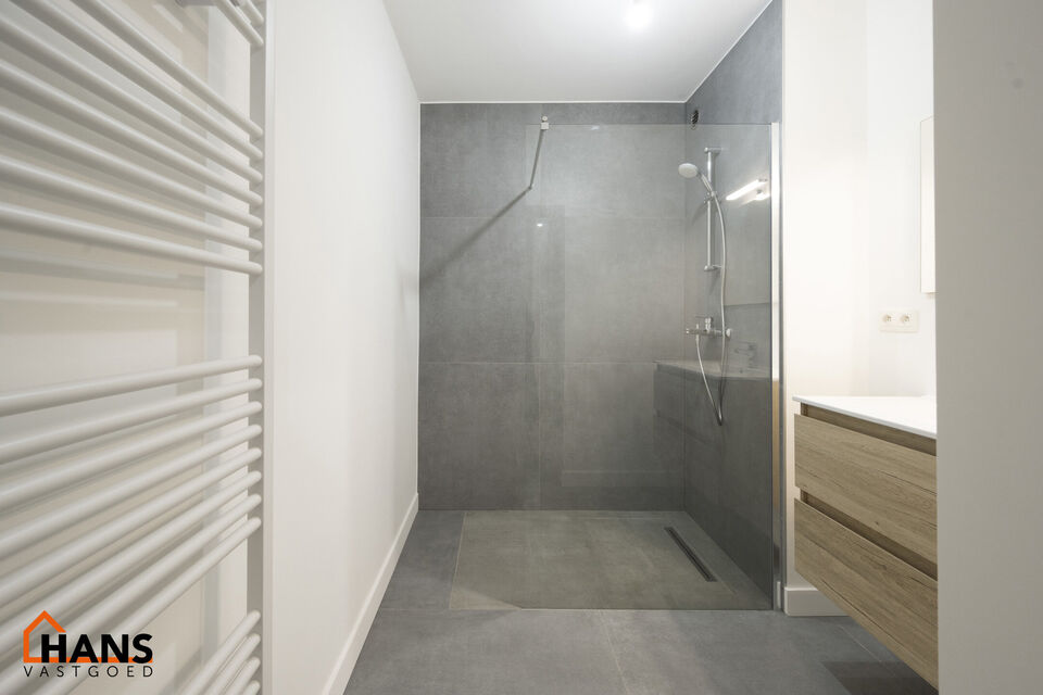 Inkomhal; apart toilet; vestiairekast; leefruimte; keuken met kasten, spoelbak, kookplaat, dampkap, oven, koelkast en vaatwasser; badkamer met inloopdouche, wastafel in meubel, spiegel en handdoekdroger; 2 slaapkamers, waarvan de kleinste toegang verschaf