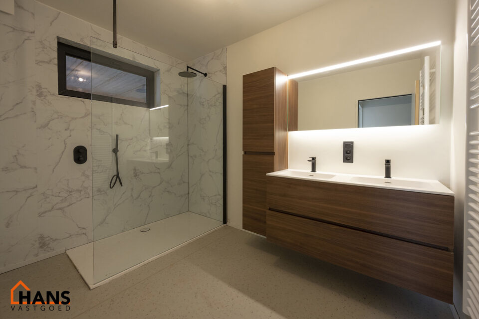 Op de gelijkvloers van een kleinschalig gebouw (zonder lift) bevindt zich dit stijlvol gerenoveerde appartement. Bij binnenkomst treft u een inkomhal met ruimte voor een vestiairekast en een gastentoilet met wastafelmeubel.

De ruime en lichtrijke woonkam