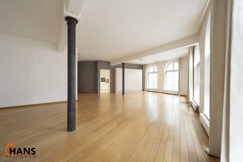 Inkomhal met vestiairekast; apart toilet met wastafel; riante, lichtrijke woonkamer van 80m² op een houten vloer met ingemaakte kasten; ruime keuken, volledig ingericht met kasten, lades en alle toestellen (gasfornuis, dampkap, vaatwasser, combi-oven, ko