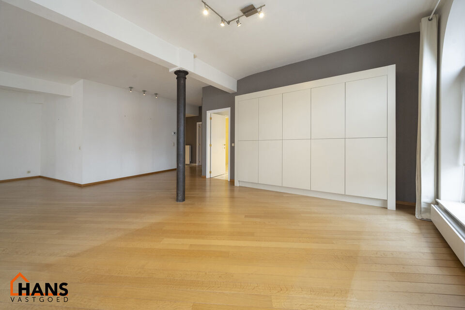 Inkomhal met vestiairekast; apart toilet met wastafel; riante, lichtrijke woonkamer van 80m² op een houten vloer met ingemaakte kasten; ruime keuken, volledig ingericht met kasten, lades en alle toestellen (gasfornuis, dampkap, vaatwasser, combi-oven, ko