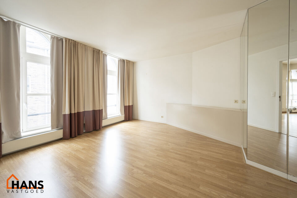 Inkomhal met vestiairekast; apart toilet met wastafel; riante, lichtrijke woonkamer van 80m² op een houten vloer met ingemaakte kasten; ruime keuken, volledig ingericht met kasten, lades en alle toestellen (gasfornuis, dampkap, vaatwasser, combi-oven, ko