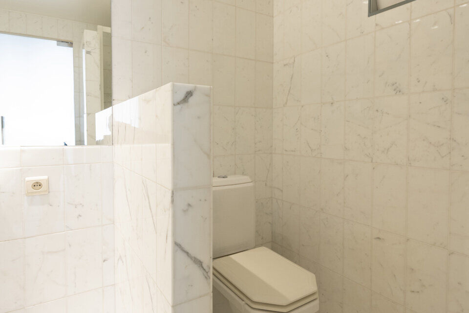 Inkomhal met vestiairekast; apart toilet met wastafel; riante, lichtrijke woonkamer van 80m² op een houten vloer met ingemaakte kasten; ruime keuken, volledig ingericht met kasten, lades en alle toestellen (gasfornuis, dampkap, vaatwasser, combi-oven, ko