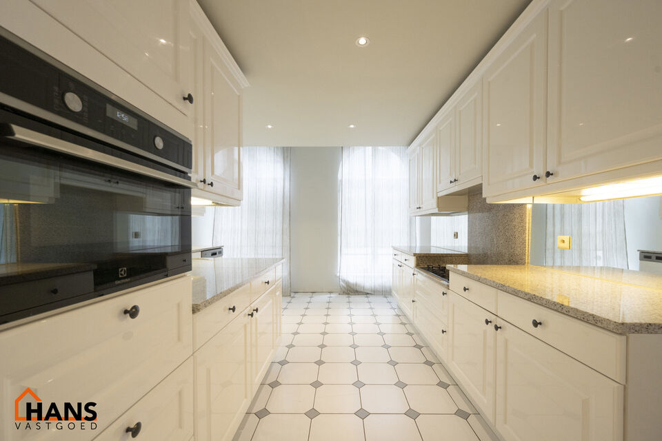 Inkomhal met vestiairekast; apart toilet met wastafel; riante, lichtrijke woonkamer van 80m² op een houten vloer met ingemaakte kasten; ruime keuken, volledig ingericht met kasten, lades en alle toestellen (gasfornuis, dampkap, vaatwasser, combi-oven, ko