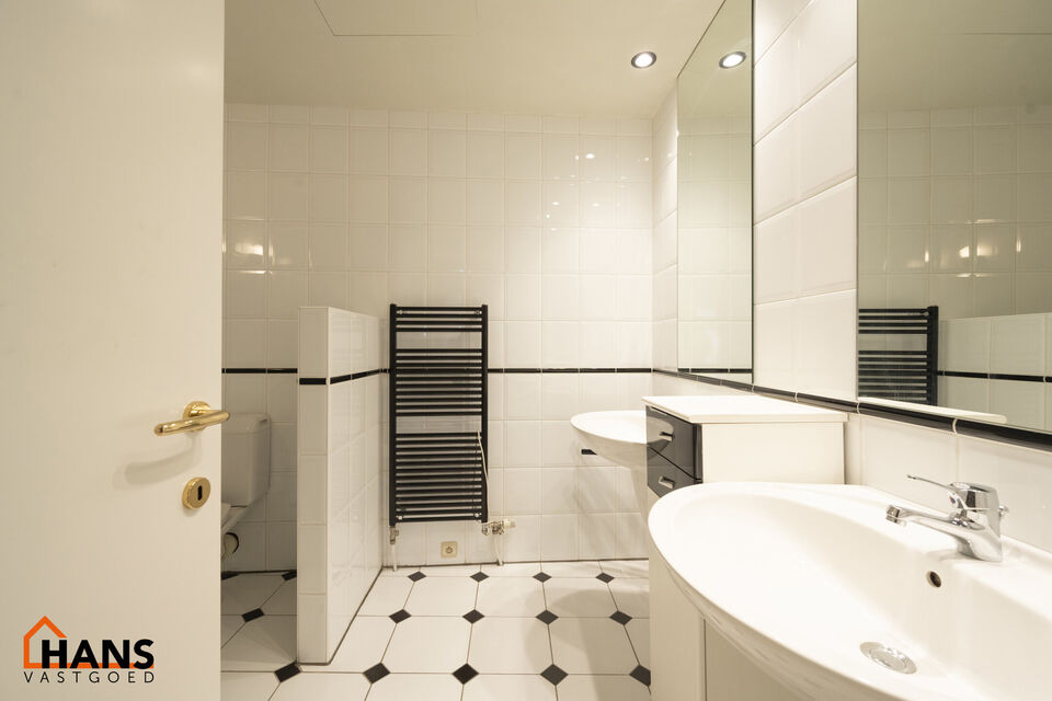 Inkomhal met vestiairekast; apart toilet met wastafel; riante, lichtrijke woonkamer van 80m² op een houten vloer met ingemaakte kasten; ruime keuken, volledig ingericht met kasten, lades en alle toestellen (gasfornuis, dampkap, vaatwasser, combi-oven, ko