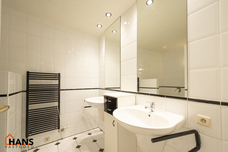 Inkomhal met vestiairekast; apart toilet met wastafel; riante, lichtrijke woonkamer van 80m² op een houten vloer met ingemaakte kasten; ruime keuken, volledig ingericht met kasten, lades en alle toestellen (gasfornuis, dampkap, vaatwasser, combi-oven, ko
