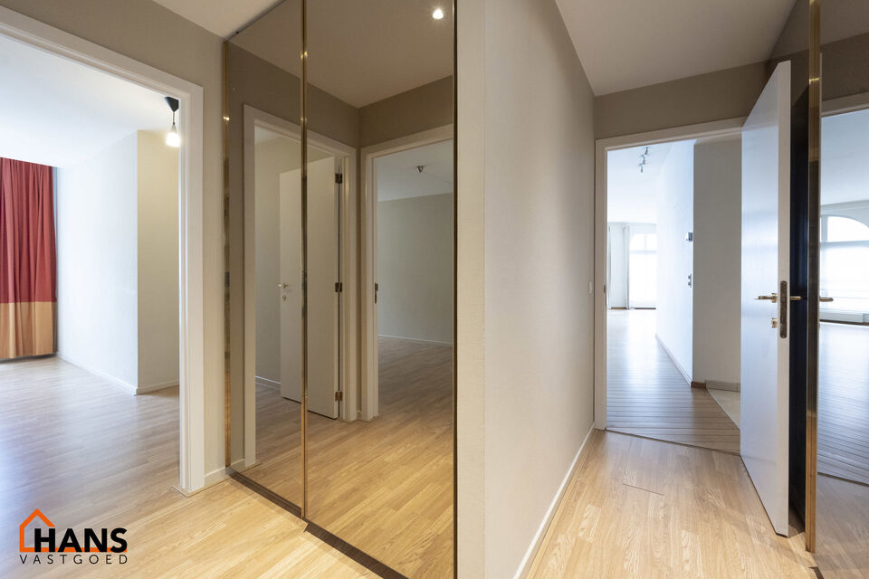 Inkomhal met vestiairekast; apart toilet met wastafel; riante, lichtrijke woonkamer van 80m² op een houten vloer met ingemaakte kasten; ruime keuken, volledig ingericht met kasten, lades en alle toestellen (gasfornuis, dampkap, vaatwasser, combi-oven, ko