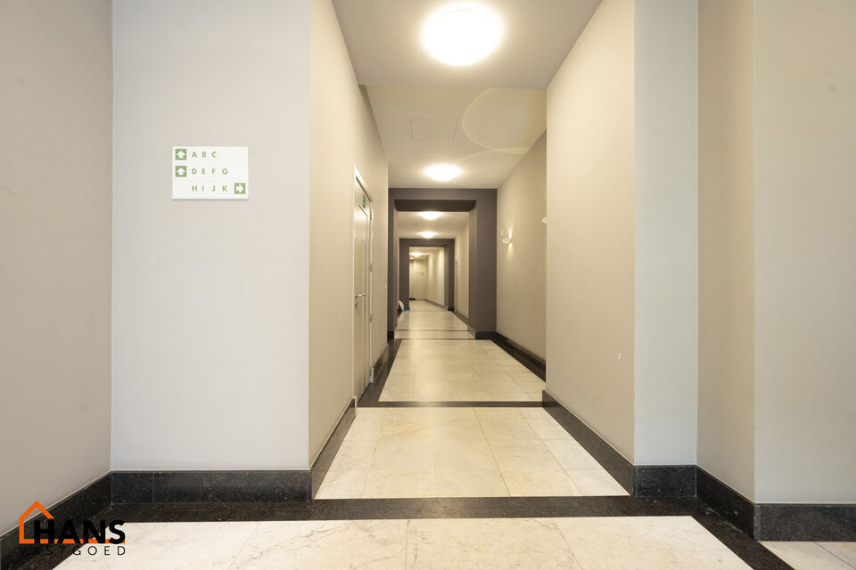 Inkomhal met vestiairekast; apart toilet met wastafel; riante, lichtrijke woonkamer van 80m² op een houten vloer met ingemaakte kasten; ruime keuken, volledig ingericht met kasten, lades en alle toestellen (gasfornuis, dampkap, vaatwasser, combi-oven, ko